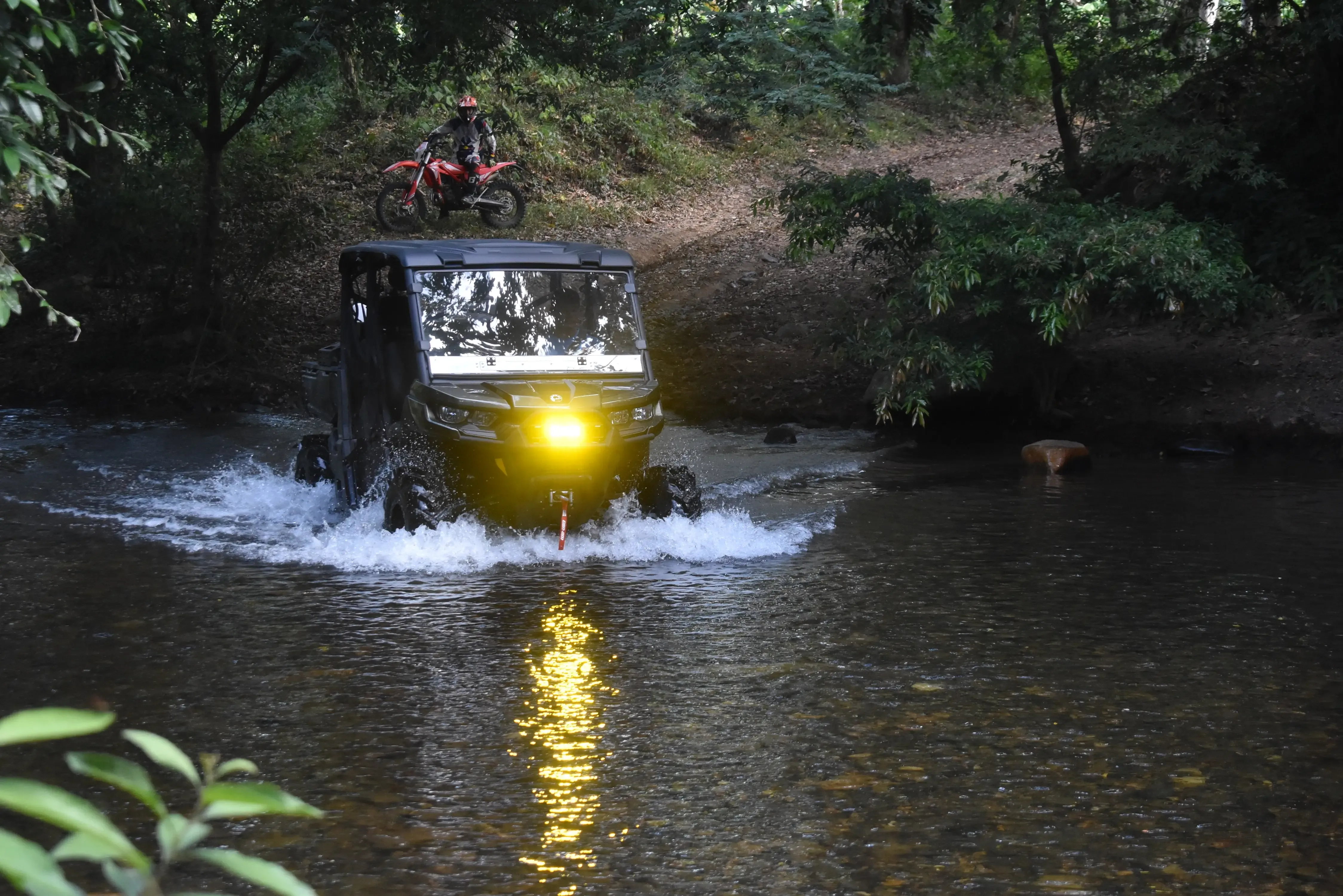 A picture of a motorcycle rider crossing a river in Panama.